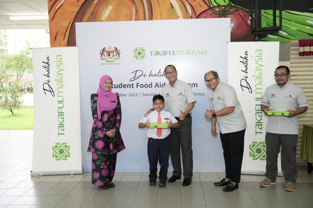 Sekumpulan orang berdiri di hadapan gerai makanan hijau.