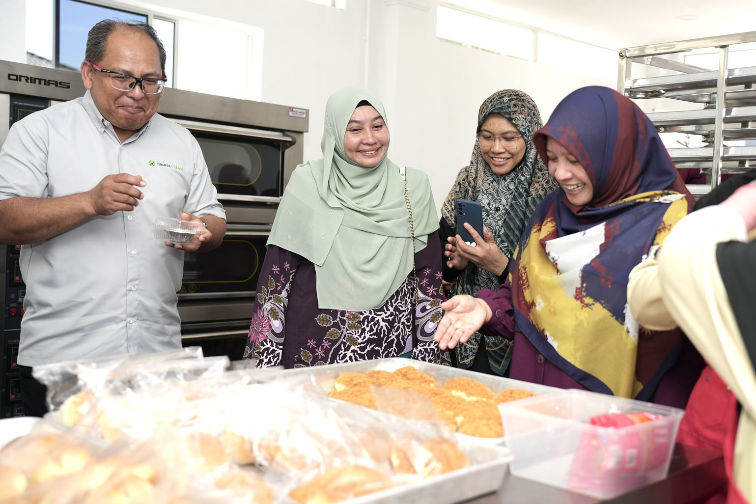 Seorang wanita berhijab sedang berdiri di hadapan sekumpulan orang.